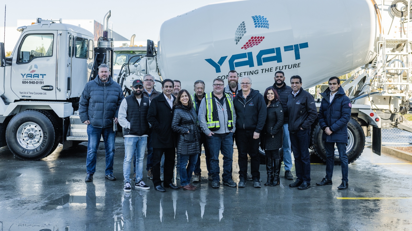 Yard At A Time Concrete team standing in front of YAAT concrete trucks