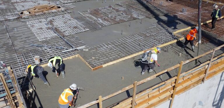 Workers pouring reinforced concrete slab, showing cost to pour concrete slab BC